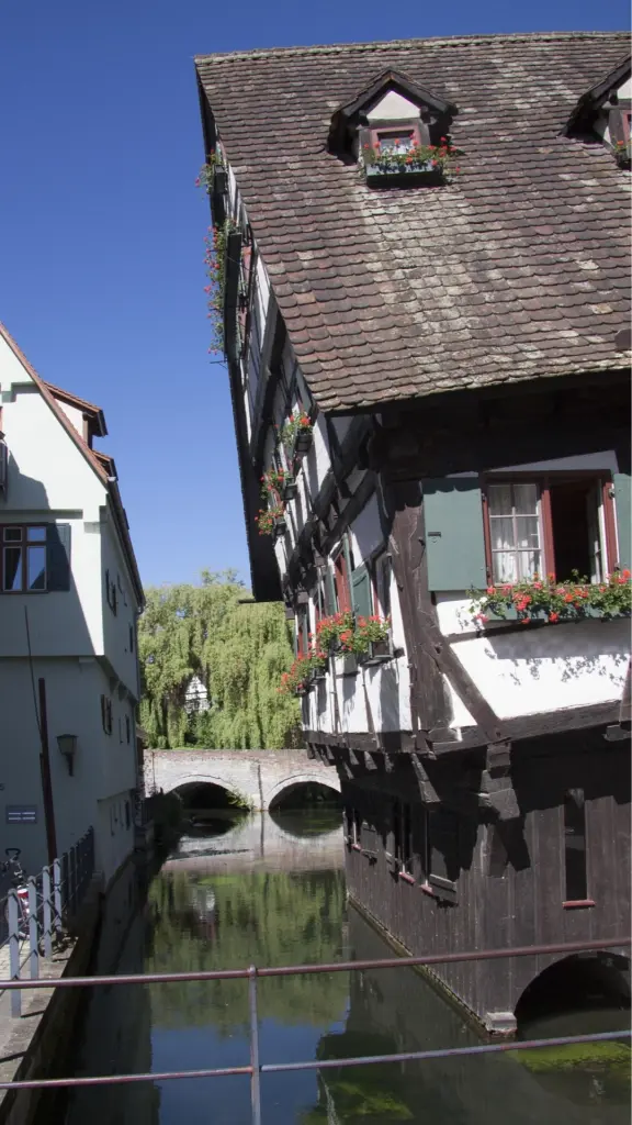 Historisches Fachwerkhaus im Ulmer Fischerviertel an einem schmalen Kanal mit kleiner Steinbrücke