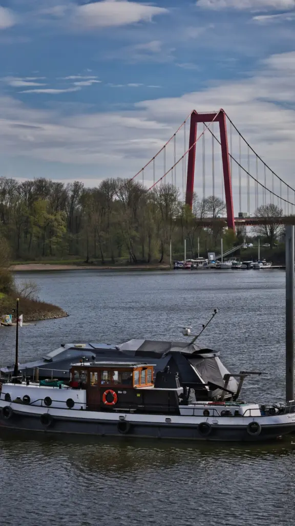 Uerdinger Rheinbrücke in Krefeld mit Rhein und Schiff als regionales Motiv für Factoring und Liquidität in Krefeld.